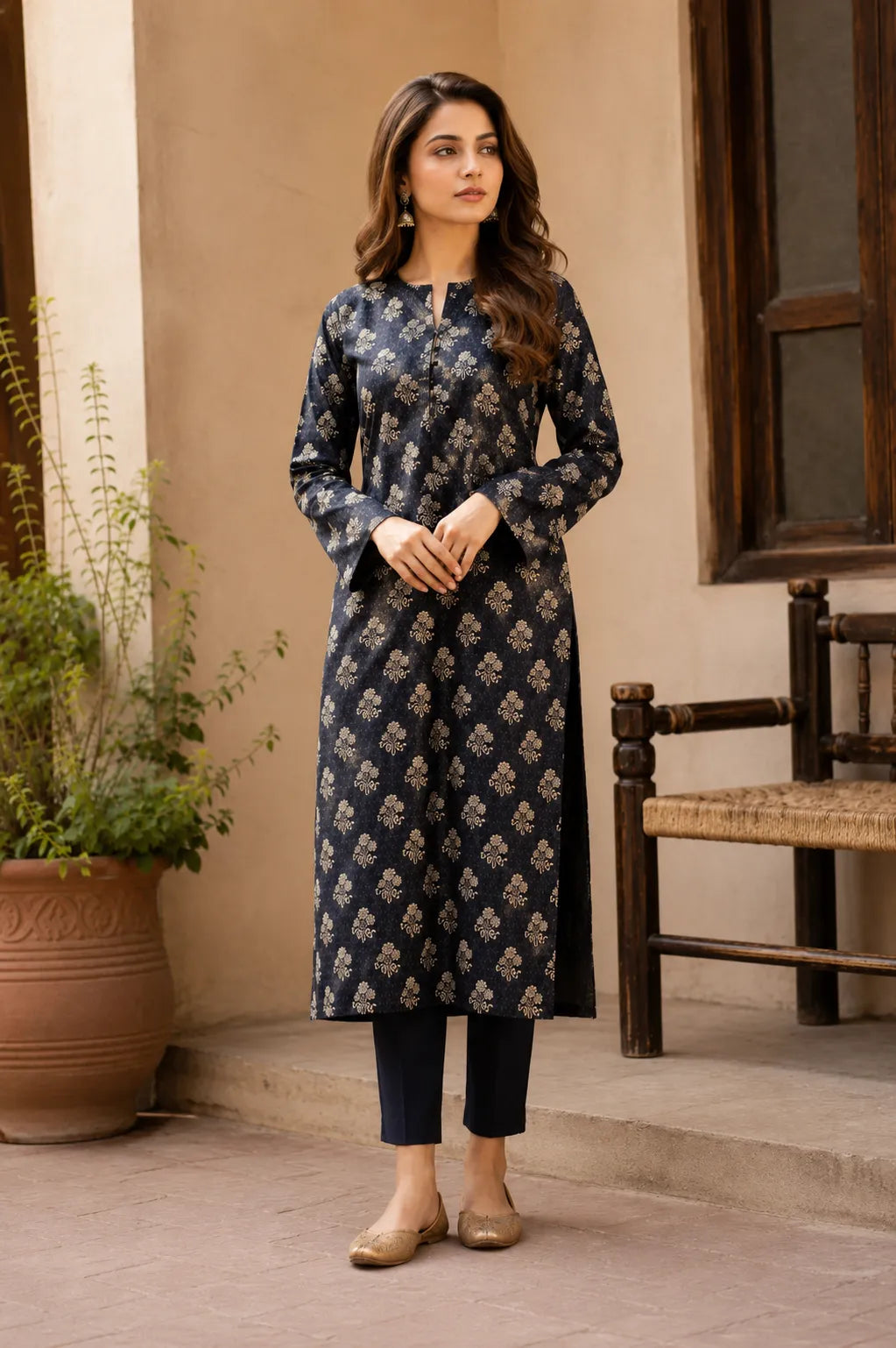 A woman wearing a long-sleeved black kurta with a beige floral block print, paired with dark cropped pants 
